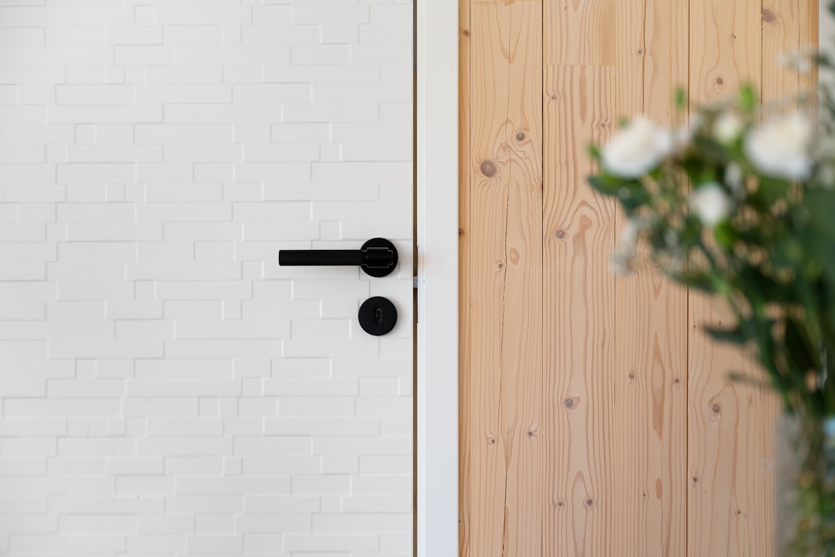 A matte black lever handle on a round rose, with a privacy turn below it